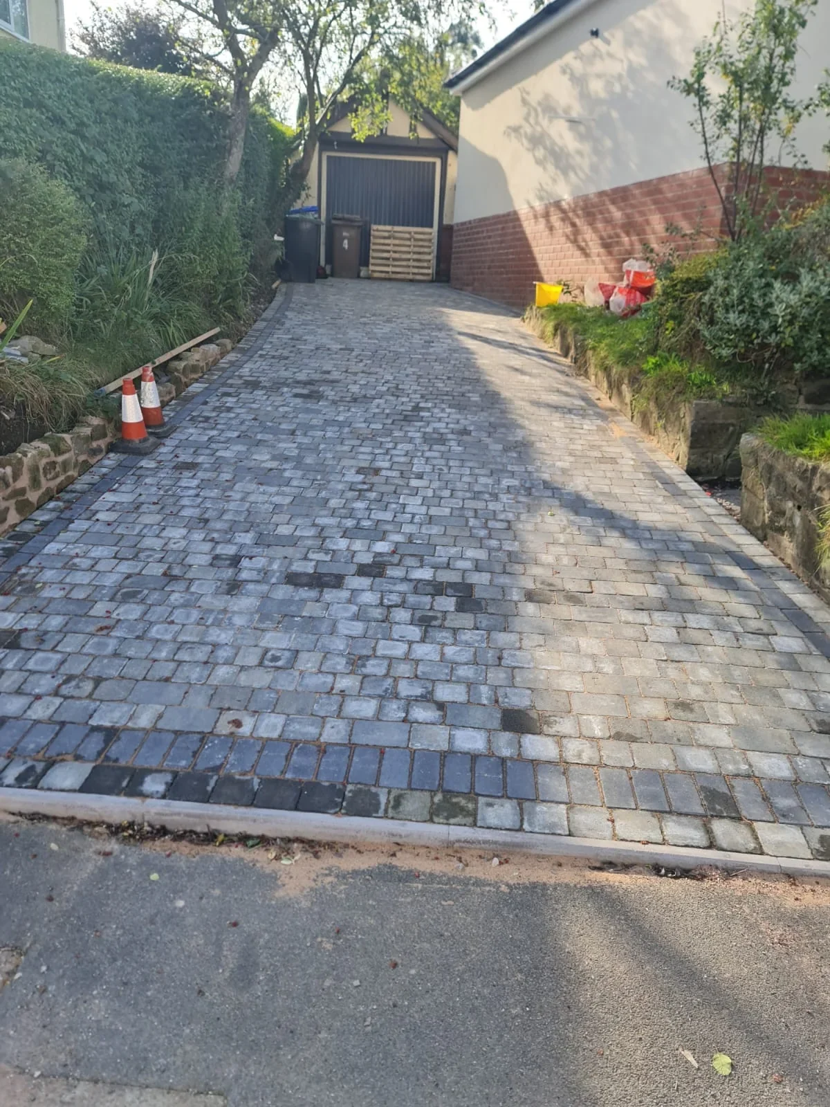Block paved driveway leading to a garage
