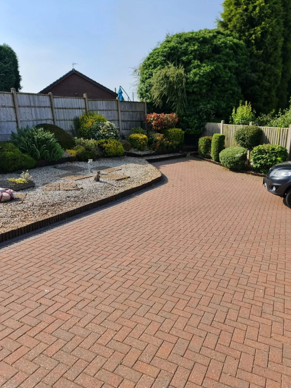 Block paved driveway with curved gravel border